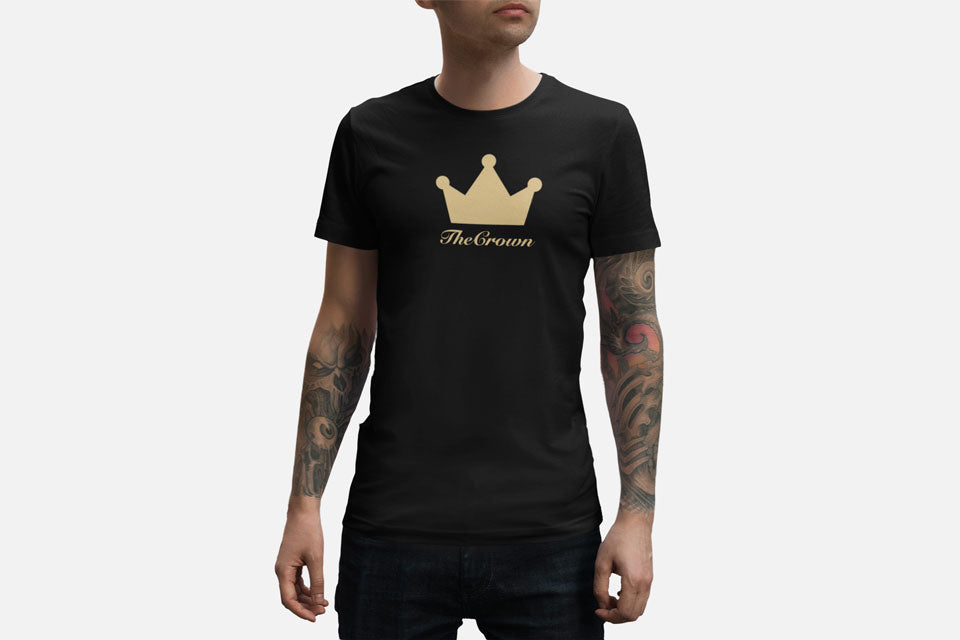 Man wearing black t-shirt with gold crown design on chest